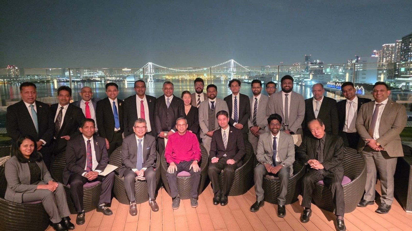 SLBCJ members gathered in Tokyo with the illuminated Rainbow Bridge behind them